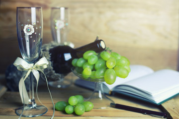wooden table with wine bottle book and grape