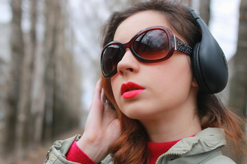 woman with headphones in park autumn