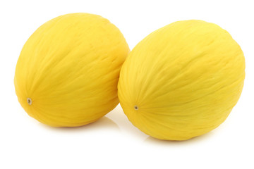 two fresh honey melons on a white background
