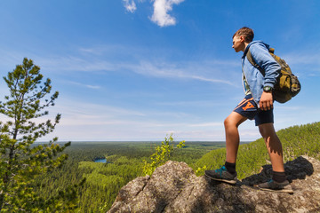 Teenager on the top of a cliff looking at Baikal lake