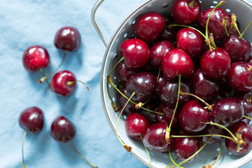 Cherries in bowl on blue tablecloth. summerfeeling