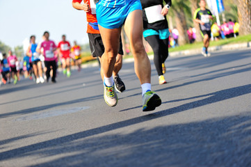 Fototapeta na wymiar Unidentified marathon athletes legs running on city road
