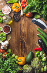 Fresh raw vegetable ingredients for healthy cooking or salad making on wooden background, copy space in center, top view. Diet , vegetarian food concept