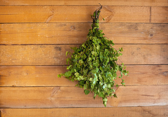 Birch broom hangs in a bath