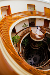 The bride and bridegroom in a spacious room with a beautiful staircase