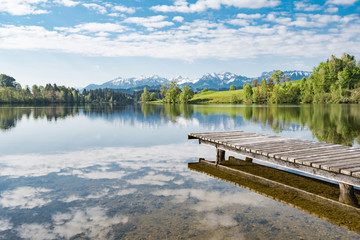 Fototapety  Romantyczne jezioro z drewnianym pomostem w Allgäu, odbicie