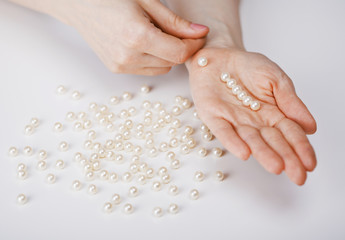 Female hands collecting beads from pearls