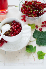 Healthy breakfast: muesli with yogurt and fresh berries in a bowl and juice on white wooden background