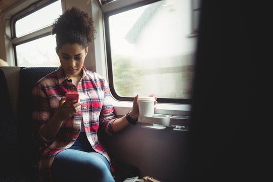 Young woman using mobile phone in train