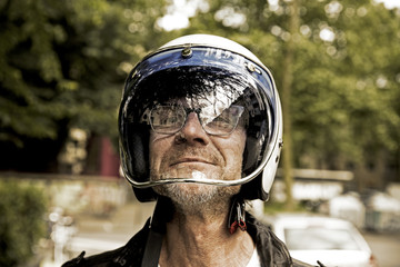Portrait of smiling biker looking through vizor of his motorcycle helmet