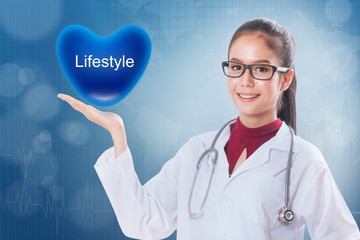 Female doctor holding heart with lifestyle sign on medical background.