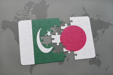puzzle with the national flag of pakistan and japan on a world map background.