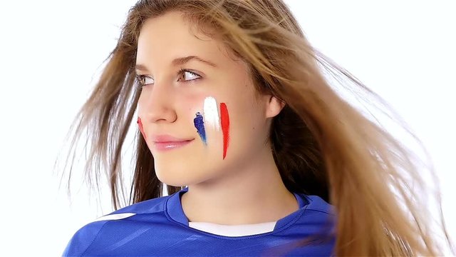 Girl with French flag on her face smiling, slow motion