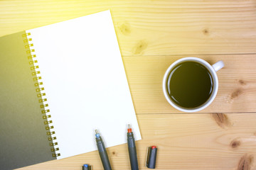 Coffee cup with note book on table