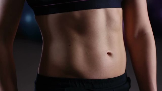 Ideal flat belly of female athlete doing breathing exercises for body wellness