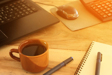 coffee cup and office desk with laptop computer