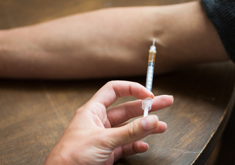 close up of addict hand making drug injection
