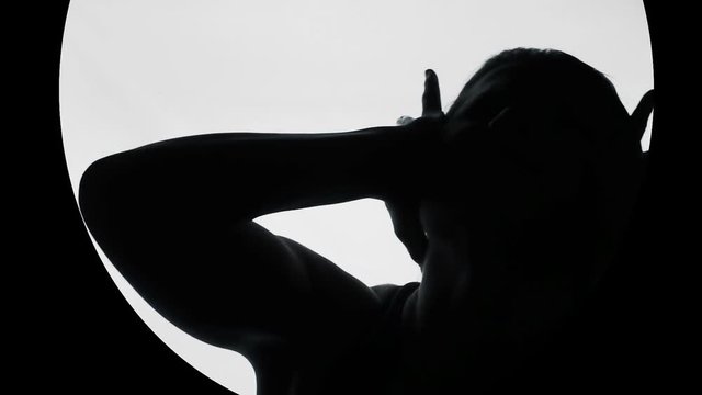 Silhouette of woman suffering from headache, covering ears from noise, horror