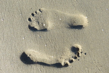 Pisadas en la arena, en sentido contrario, que muestra caminos separados, distanciamiento, incomprensión o una oportunidad a aprovechar