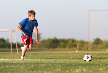 Naklejka premium Boy playing football