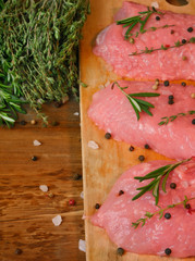 Pieces of pork on the cutting board, salt, spicy herbs