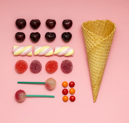 Sweet construction set / Creative photo of a waffle cone with fruits and sweets on pink background.