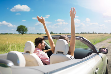 Couple enjoying a drive in a convertible
 - obrazy, fototapety, plakaty
