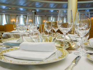 Empty glasses set, plate and silverware in restaurant. Table setting for celebration.
