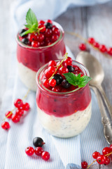 Layered berry and chia seeds smoothies in jar for breakfast on white rustic wooden background, selective focus