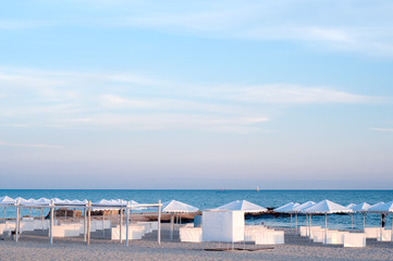 Fototapeta na wymiar many sun umbrellas in the warm sandy beach