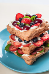 Pavlova dessert with strawberry , blueberry , cherry and mint