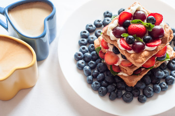 Pavlova dessert with strawberry , blueberry , cherry and mint