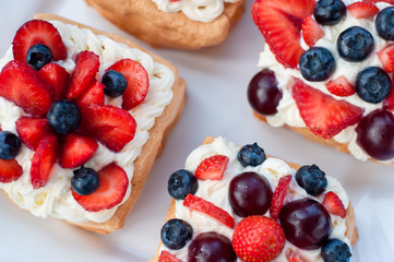 Pavlova dessert with strawberry , cherry and blueberry
