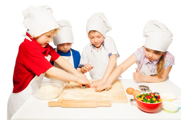 Happy bakers making cookies with cookie cutters