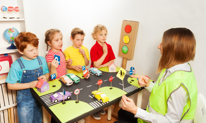 Happy kids teaching traffic signs in kindergarten