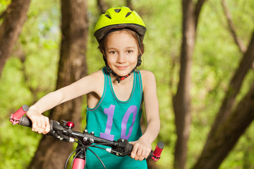Sporty girl driving her mountain bike by handlebar