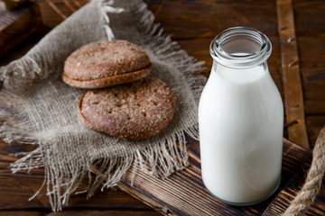 Natural whole milk in bottle and on old wooden background