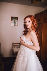 Fototapeta premium beautiful red hair stylish bride getting ready in the morning in the room