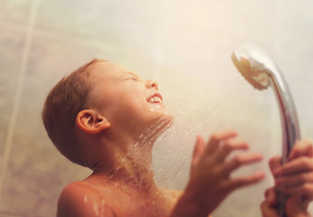 Portrait of cute  boy having shower with eyes closed