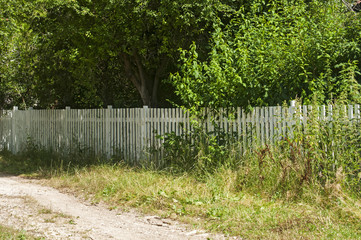 Countryside courtyard fence with white wooden laths