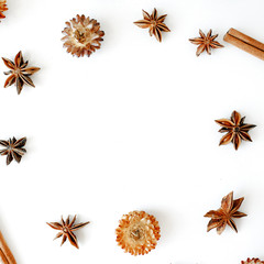 Fototapeta premium dry flowers, cinnamon and cardamom round frame wreath pattern on white background. flat lay, top view