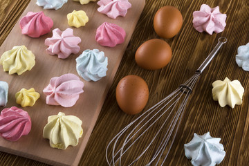 Board of homemade pastel colored meringue cookies.