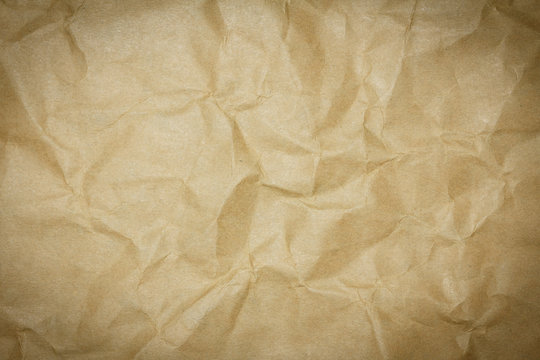 Crumpled brown paper texture or paper background for design with copy space for text or image. Dark edged.