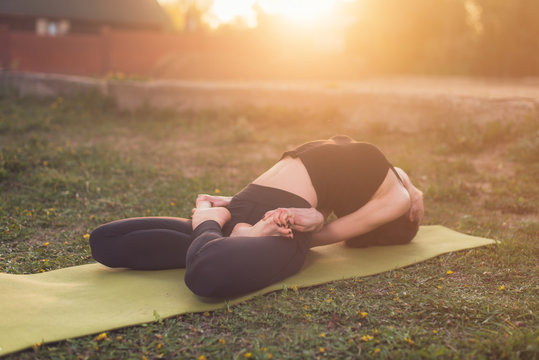 woman practicing outdoors meditating in yoga position.