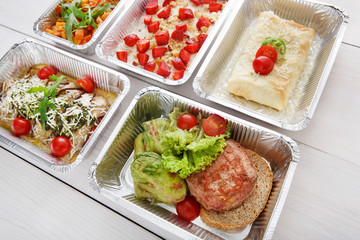 Healthy food take away in boxes, top view at wood