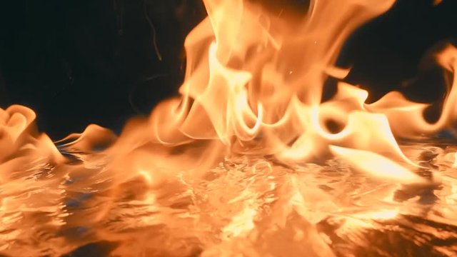 Sparks from flint from a set of survival is fall down and ignites the gasoline. Blue wave at the forefront of fire go to meet. S-log - High Dynamic Range. Slow motion, high speed camera, 250fps