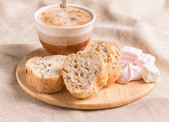 sweet buns, meringues and coffee cup on a wooden board