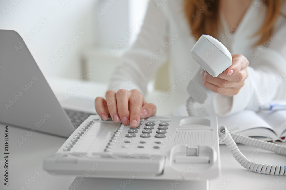 Wall mural Businesswoman with office IP telephone