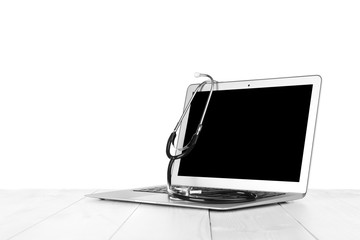 Laptop with stethoscope, isolated on white