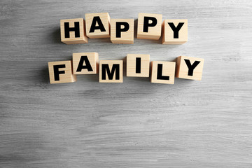 Naklejka premium Happy family with wooden blocks spelling out words on a textured gray background togetherness and domestic bliss, this arrangement togetherness domestic bliss and the importance of familial bonds